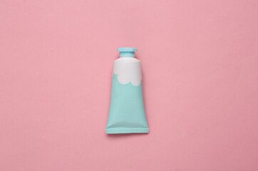 Tube of cream on pink background. Top view. Minimalism