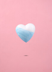 Obraz premium Levitating heart with dripping paint paint on a pink background. Minimal creative layout. Concept art.