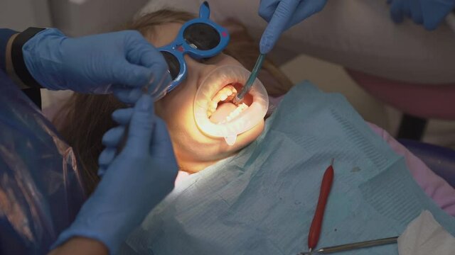 kid girl with oral dilator at dentist's appointment. treatment of teeth