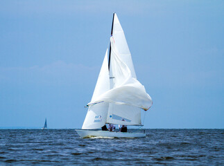 Obraz premium Yacht with white sails on the water, sea and river transport, blue sky, beautiful background. 