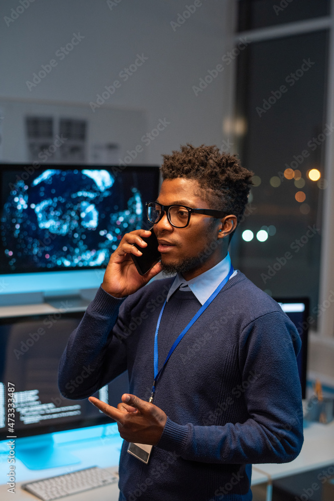 Poster Young well-dressed programmer communicating on smartphone to one of clients of cyber security service company