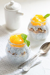 Healthy Chia Pudding with Coconut Milk, mango, chia seeds, granola in a Glass. Concept of healthy eating, healthy lifestyle, dieting, fitness menu. 