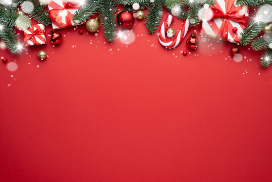 Red Christmas background with fir ornaments and holiday gifts