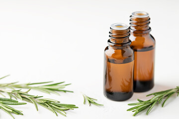 Rosemary essential oil in glass bottles on a light background. Aromatherapy.