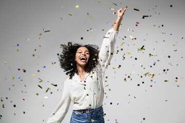 Happy woman at celebration party with confetti falling everywhere on her, Birthday or New Year eve celebrating concept - obrazy, fototapety, plakaty