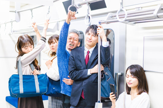 満員電車で通勤をするビジネスパーソン