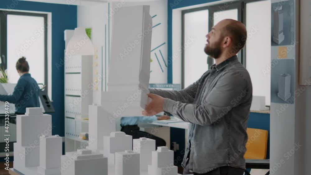 Poster man architect analyzing building model and maquette to design urban property. architectural worker d