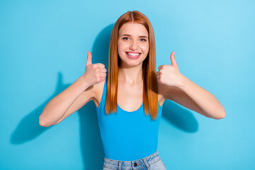 Photo of pretty charming young woman wear top singlet showing two thumbs up smiling isolated blue color background