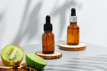 Fruit essential oil in glass bottle on gray background