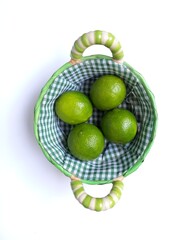 Lime. Lemon in the basket. White Background. Green.