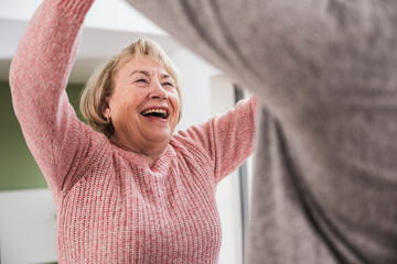 Happy woman cheering with caregiver at home