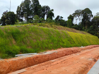 Permanent slope protection with grass using the hydroseed method. The grass is used to stabilizes the slope structure and prevent slope erosion. Effective and less maintenance. 
