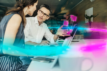 Businessman discussing with colleague over augmented chart in office