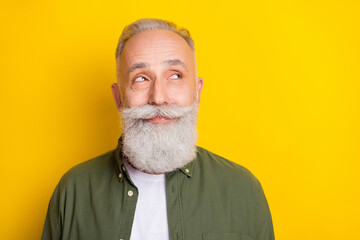 Photo portrait of senior man smiling curious looking copyspace isolated on bright yellow color...