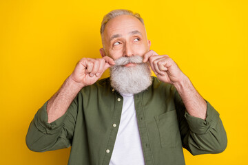 Photo portrait of senior man touching mustache looking dreamy empty space isolated vibrant yellow color background