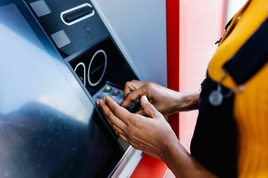 Woman entering pin in ATM machine