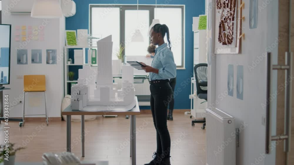 Poster engineer working on blueprints design with digital tablet and building model at work. woman architec