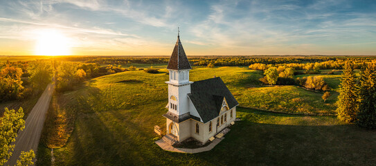 An old country church in the Great Plains during sunset with fall colors in North Dakota.