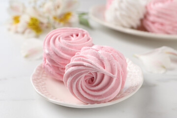 Plate with delicious pink zephyrs on white table, closeup