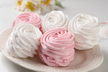 Plate with delicious pink zephyrs on white table, closeup