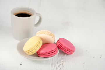 closeup macaroons and cup of coffee on table