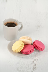 colorful macaroons and cup of coffee on table