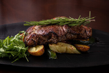 Grilled striploin steak on black dish. steak with fried potatoes and vegetables, Grilled beef steak with rosemary