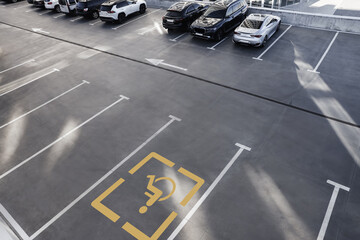 Car parking lot with white marking lines and wheelchair symbol outdoors, above view © New Africa