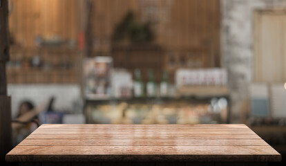 Empty wooden table top with lights bokeh on blur restaurant background.