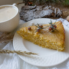 Cup of latte coffee and piece of apple pie on a decorated holiday table