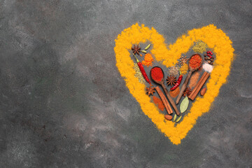 Various spices in the shape of a heart on a dark rustic background. Valentine's Day. View from...