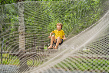 practice nets playground. boy plays in the playground shielded with a protective safety net....