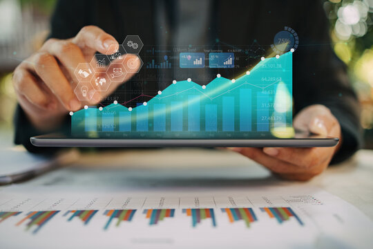 Business analyzing big data screen and economic growth with financial diagram graph interfaces. Concept of virtual dashboard technology digital marketing and global network connection from tablet.