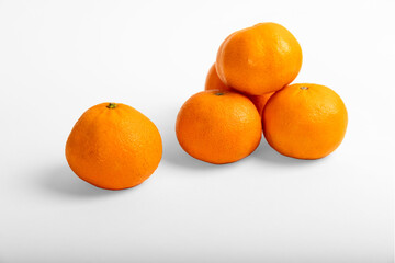 Orange colored mandarin and clementine fruits with green leaves isolated on white background.