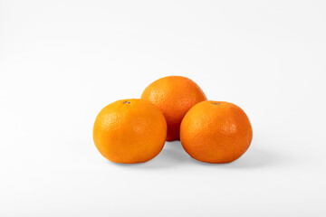 Orange colored mandarin and clementine fruits with green leaves isolated on white background.