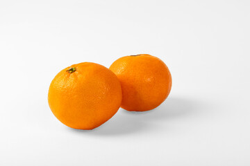 Orange colored mandarin and clementine fruits with green leaves isolated on white background.