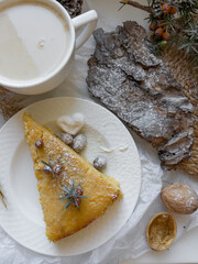 Cup of latte coffee and piece of apple pie on a decorated holiday table