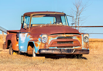 A rusty old classic truck in a farmers field