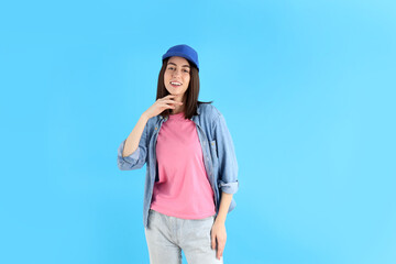 Attractive girl in cap on blue background