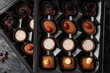 Concept of sweets with chocolate candies on dark textured background