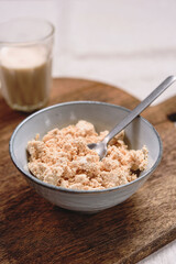 Homemade melted cheese curd served with baked milk on wooden cutboard. Healthy breakfast. Haze effect. Selective focus