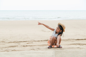 asia cute small girl playing in sand on the beach, travel the sea thailand