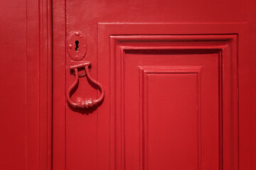 Detail of a red door with red door knocker