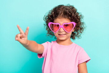 Portrait of attractive cheerful girl wearing big specs showing v-sign isolated over bright teal turquoise color background