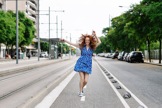 Carefree woman dancing on road