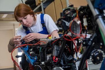 Female technician repairing motorcycle at workshop