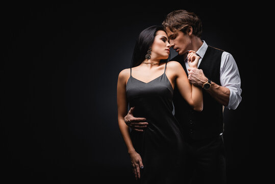 Man In Vest And Shirt Hugging Sexy Girlfriend In Silk Slip Dress Isolated On Black.