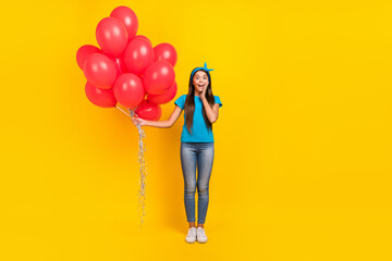Full body photo of young pretty girl excited unexpected hold many inflate balloons isolated over...