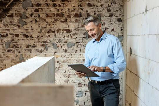 Male architect using digital tablet at construction site