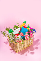 Creative bright spring cleaning concept. Tools, bottles, accessories for cleaning house with spring flowers and leaves hang on clothesline, box, bright sun light copy space